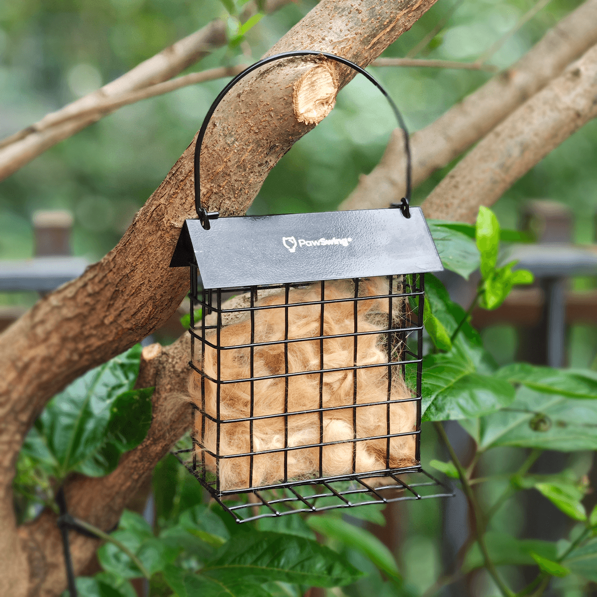 Hanging PawSwing® cat hair cage in a tree, promoting the eco friendly cat hair reuse initiative
