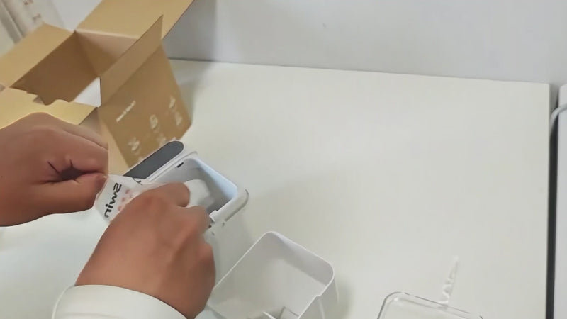 A person placing a fresh PawSwing® cat snack desiccant pack into the integrated snack storage bin