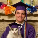 Cat owner wearing graduation uniform holding cat